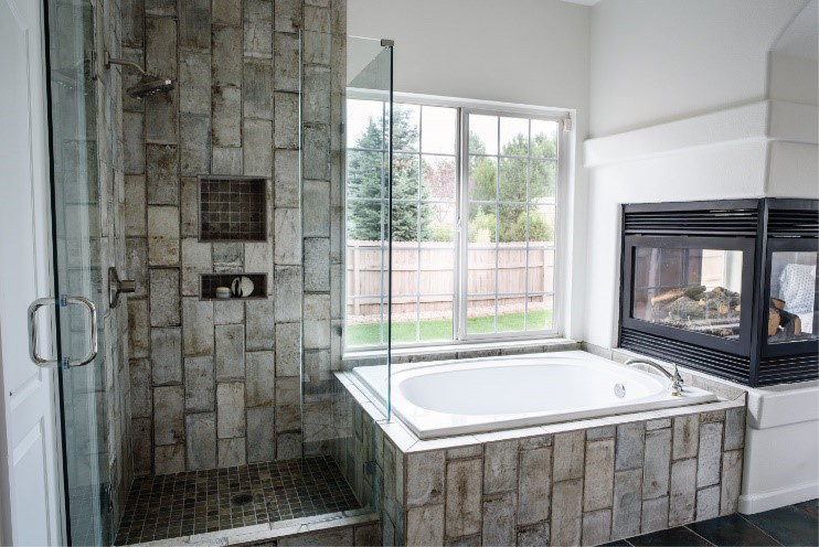 A remodeled bathroom with a bathtub and a shower area.